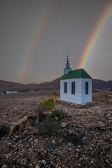 small cute white wooden chapel in a barren volcanic landscape. Sunrise, landscape shot of Ermita...