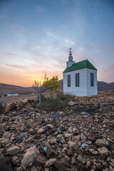 small cute white wooden chapel in a barren volcanic landscape. Sunrise, landscape shot of Ermita...