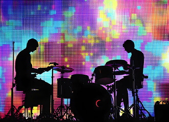 Dynamic silhouette of musicians performing against vibrant led backdrop capturing the essence of live music and artistic expression creating an immersive visual experience