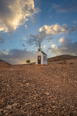 small cute white wooden chapel in a barren volcanic landscape. Sunrise, landscape shot of Ermita...