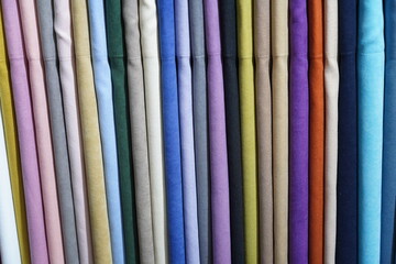 Multicolored fabrics are hung in one row. Textile. Background.