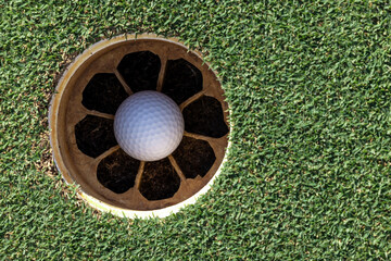 In the hole, White golf ball on green grass with golf hole, Golf ball ready to be shot, Golf ball...
