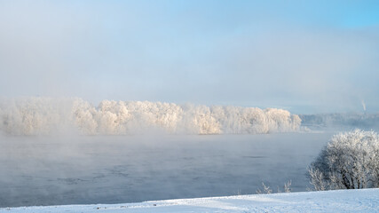 Aerial winter morning landscape with river, water, forest and steam on the water.	