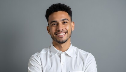 Obraz premium a young man in a white shirt posing in front of gray backgrounds with.