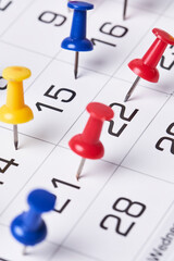 Colored push pins on monthly calendar page