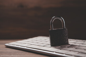 laptop computer with padlock on wooden table.