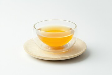 Clear Glass Bowl with Herbal Tea on Wooden Coaster Against White Background