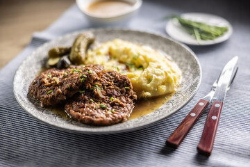 Inverted Beef Schnitzel with Mashed Potatoes and Pickled Cucumbers. Traditional Czech and Slovak Food
