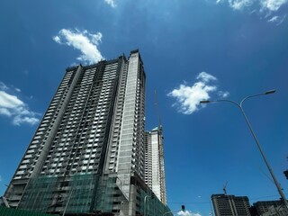 A building under construction, with scaffolding wrapping around the structure, showcasing ongoing progress, skyscrapers in the city