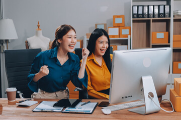 Asian SME business women use laptop computer checking customer order online shipping boxes at home....