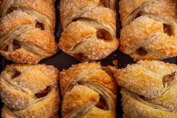 Freshly baked apple strudels with crispy sugar crust. A close-up view of freshly baked apple...