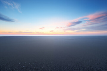 Fototapeta premium serene beach at sunrise with colorful sky and calm horizon
