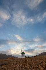 small cute white wooden chapel in a barren volcanic landscape. Sunrise, landscape shot of Ermita...