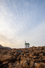small cute white wooden chapel in a barren volcanic landscape. Sunrise, landscape shot of Ermita...