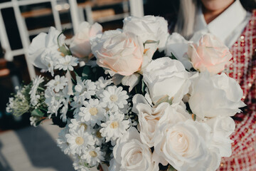 Beautiful Arrangement of White and Pink Roses and Daisies in a Woman's Hands at a Floral Celebration