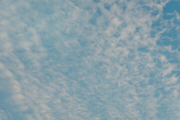 Beautiful Blue Sky with Fluffy White Clouds Spreading Across a Calm Horizon on a Clear Day