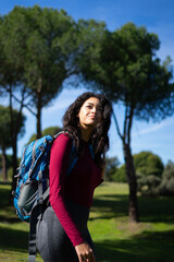 Naklejka premium Young latin woman hiking in nature with backpack enjoying sunny day