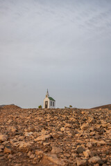 small cute white wooden chapel in a barren volcanic landscape. Sunrise, landscape shot of Ermita...