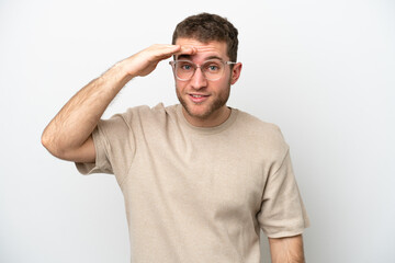 Obraz premium Young caucasian man isolated on white background looking far away with hand to look something