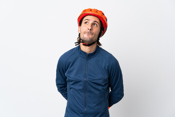Young cyclist man isolated on white background and looking up