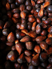 Obraz premium Pile of fresh salak (snake fruit) showcasing their unique scaly skin and earthy tones.