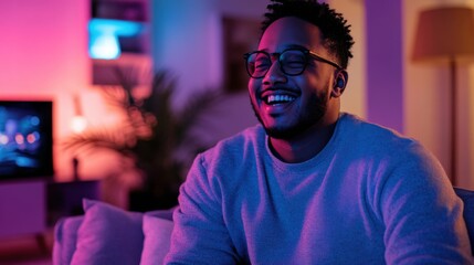 Obraz premium Joyful man relaxing at home with colorful lights in the evening