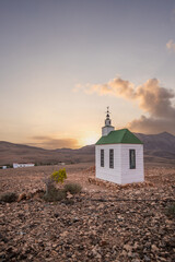 small cute white wooden chapel in a barren volcanic landscape. Sunrise, landscape shot of Ermita...