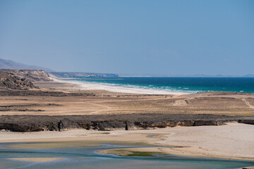 Obraz premium Desert coastline meeting the ocean in southern oman