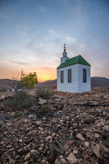 small cute white wooden chapel in a barren volcanic landscape. Sunrise, landscape shot of Ermita...