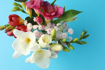 Bouquet of beautiful flowers on light blue background, top view