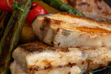 Succulent, grilled fish served with vibrant asparagus and roasted red peppers, showcasing a delicious arrangement of colorful, healthy ingredients.