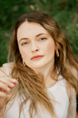 A young girl on a grass in the park with smooth skin looking up and very relaxed 