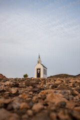 small cute white wooden chapel in a barren volcanic landscape. Sunrise, landscape shot of Ermita...