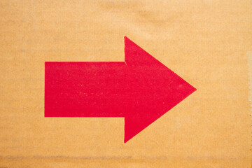 red arrow on old brown cardboard texture background and wallpaper