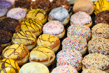 Colorfully decorated Berliners (doughnuts) are on display in the bakery. Pastries made from sweet yeast dough for carnival time