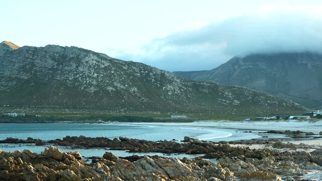 Scenic mountain backdrop with ocean waves in False Bay near Pringle Bay, South Africa. Serene coastal landscape with dramatic sky