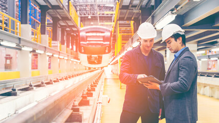 Electric train technician engineer with blueprints checking controls system for security functions...