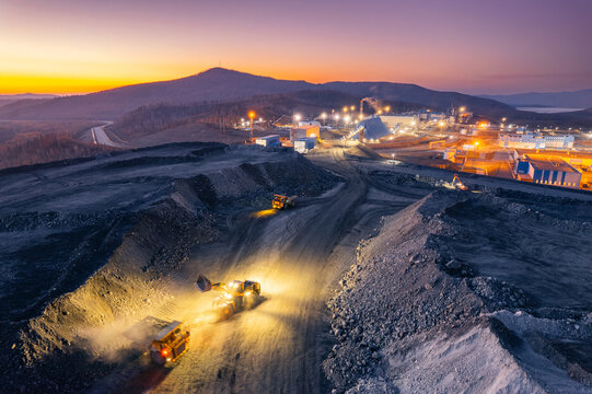 Night work of truck on open pit mine, extractive industry for gold and copper ore, top view aerial drone