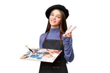Young artist man holding a palette over isolated chroma key background smiling and showing victory sign