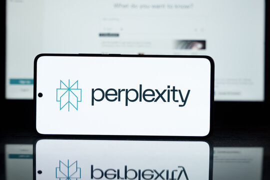 Smartphone displays Perplexity logo. Website screen blurred in background. AI Tech concept