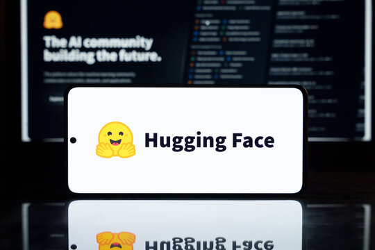 Hugging Face AI logo with a smiling face icon on a smartphone screen.