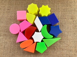 Children's toys in various shapes of flat shapes or colorful two-dimensional geometric objects which are usually used for puzzles on a table, there are triangles, hexagons, trapezoids, kites, circles,