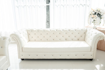 In a room that sparkles with mirrored walls and sun-drenched light, a sophisticated sofa set exudes elegance and style.