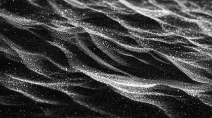 A textured sandy surface, with small grains of sand forming natural waves and ridges as they are shaped by the wind.