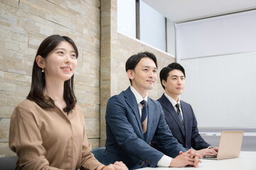 オフィスで働く男女のチームの横顔の横並び　未来と希望を見つめる、目標を目指すイメージ　右にコピースペースあり