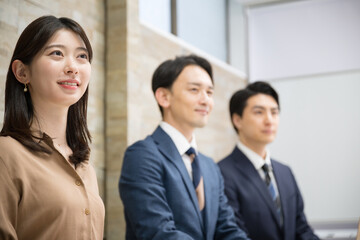 オフィスで働く男女のチームの横顔の横並び　未来と希望を見つめる、目標を目指すイメージ　女性にピントでクローズアップ