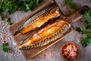 Smoked mackerel on a wooden board on a gray background for dinner. Smoked mackerel for lunch. View from above. Close-up