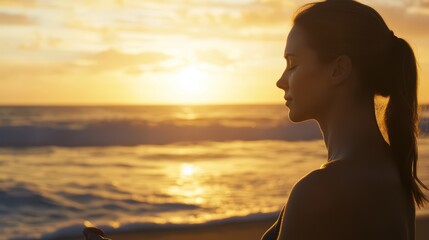 Fototapeta premium Serene female meditating on beach at sunset with ocean waves in background