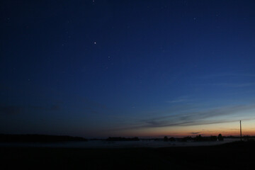Starry Night Sky Over a Misty Landscape