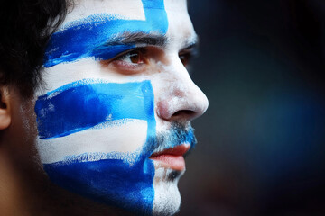 Face painted with Greek flag colors during a celebration of Greece&rsquo;s national pride and independence